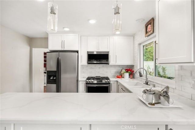 kitchen with sink, white cabinetry, appliances with stainless steel finishes, and hanging light fixtures