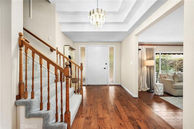 entryway with dark wood-type flooring and a notable chandelier