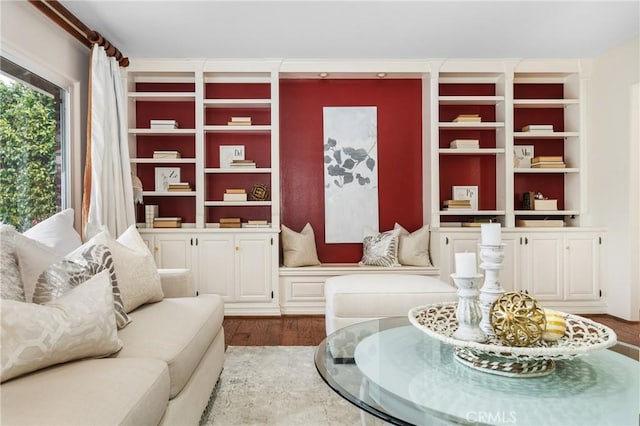 living area with built in features and hardwood / wood-style floors