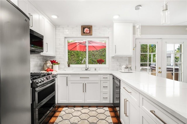 kitchen with white cabinets, pendant lighting, and appliances with stainless steel finishes