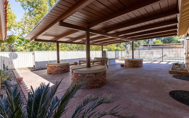 view of patio / terrace with an outdoor fire pit, a fenced backyard, and a fenced in pool