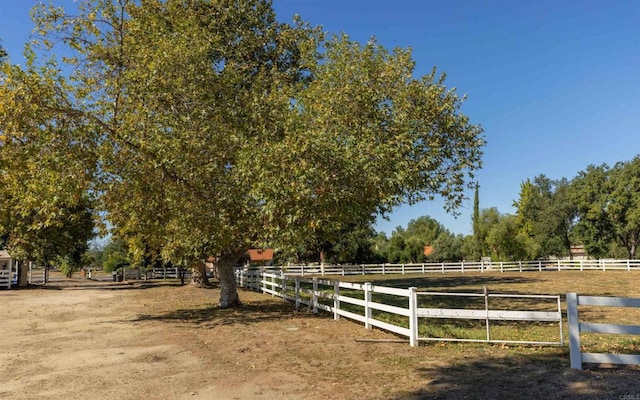 view of yard with fence and a rural view