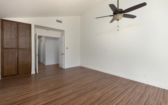 unfurnished bedroom with lofted ceiling, dark wood finished floors, visible vents, and baseboards