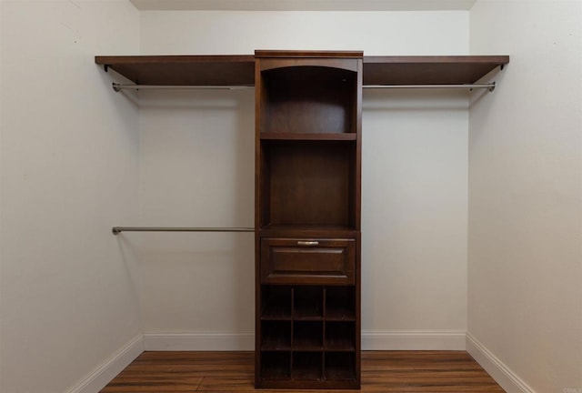 walk in closet with dark wood-type flooring