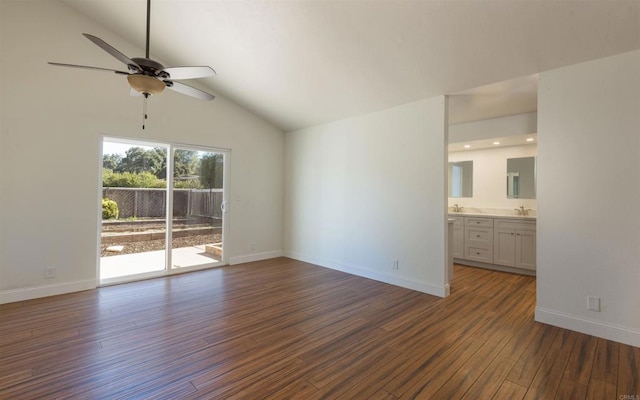 unfurnished living room featuring dark wood-type flooring, vaulted ceiling, baseboards, and ceiling fan