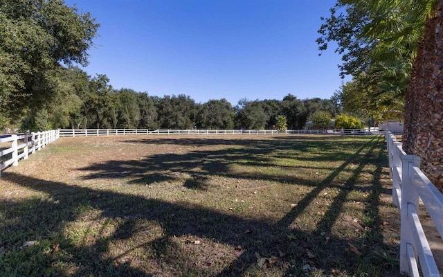 view of yard with a rural view and fence