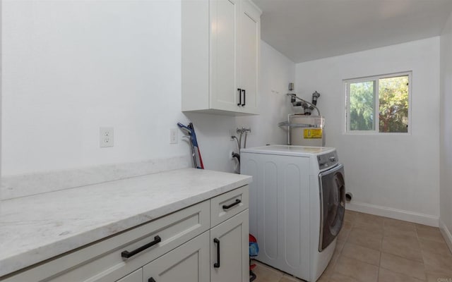 laundry room with strapped water heater, cabinet space, light tile patterned flooring, washer / dryer, and baseboards