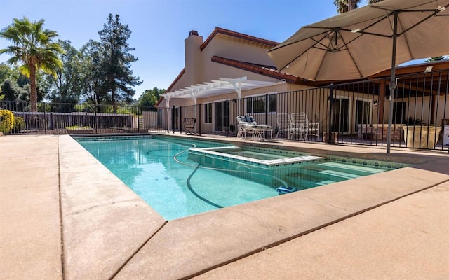 view of swimming pool featuring a patio area, fence, a pool with connected hot tub, and a pergola