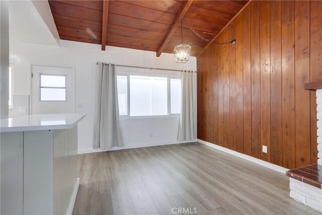 interior space with a chandelier, a wealth of natural light, wood ceiling, and light hardwood / wood-style flooring