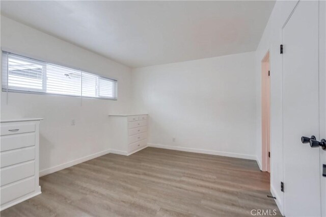 spare room with light hardwood / wood-style flooring