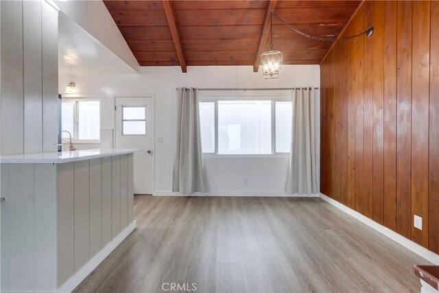 kitchen featuring hanging light fixtures, wood ceiling, light hardwood / wood-style flooring, and lofted ceiling with beams