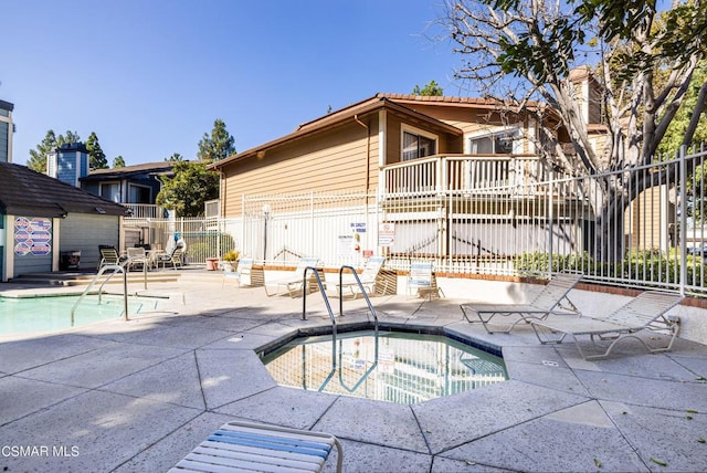 view of swimming pool featuring a hot tub and a patio