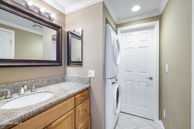 bathroom with stacked washer and dryer, crown molding, tile patterned floors, and vanity