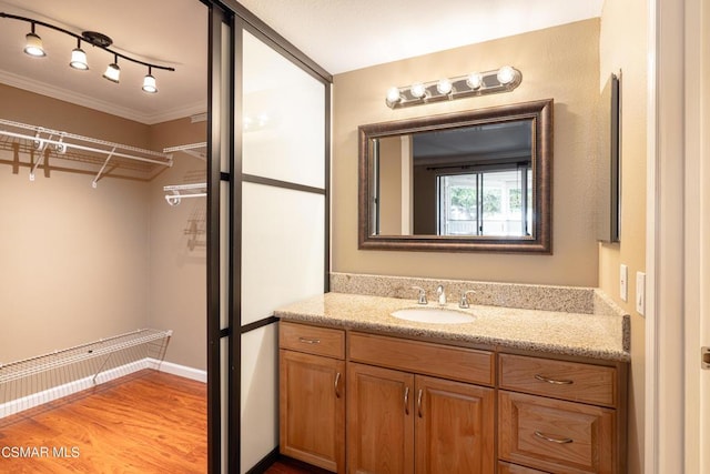 bathroom featuring vanity, crown molding, and hardwood / wood-style floors