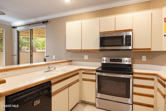 kitchen featuring tile countertops, sink, light tile patterned flooring, appliances with stainless steel finishes, and ornamental molding