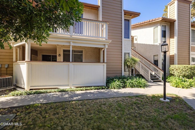 view of front of property with a balcony and central air condition unit