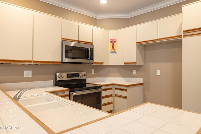 kitchen with sink, appliances with stainless steel finishes, and tile counters