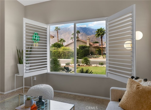 living area with baseboards, a mountain view, and carpet