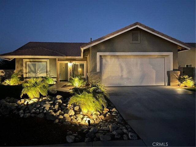 ranch-style house with a garage, stucco siding, and driveway