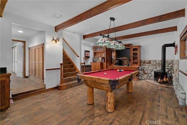 playroom featuring dark hardwood / wood-style floors, beam ceiling, a wood stove, and billiards