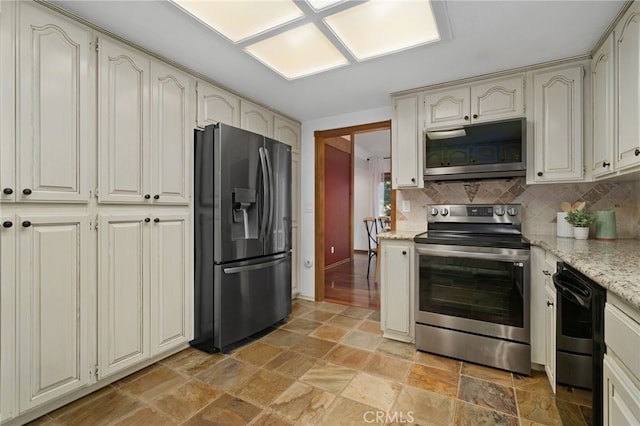 kitchen with light stone countertops, appliances with stainless steel finishes, and tasteful backsplash