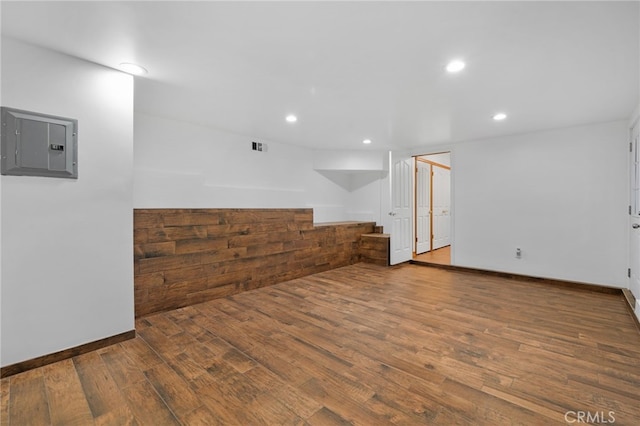 empty room with hardwood / wood-style floors and electric panel