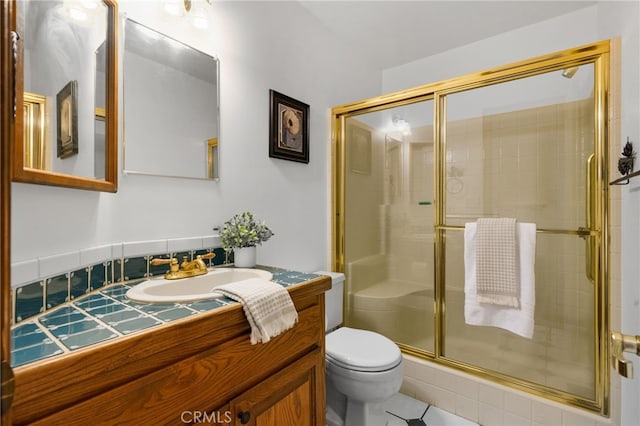 bathroom featuring tile patterned floors, vanity, toilet, and a shower with shower door