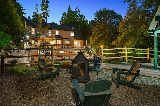 exterior space featuring a balcony and an outdoor fire pit