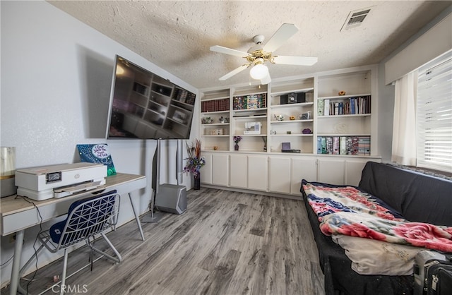 home office featuring a textured ceiling, ceiling fan, and hardwood / wood-style flooring