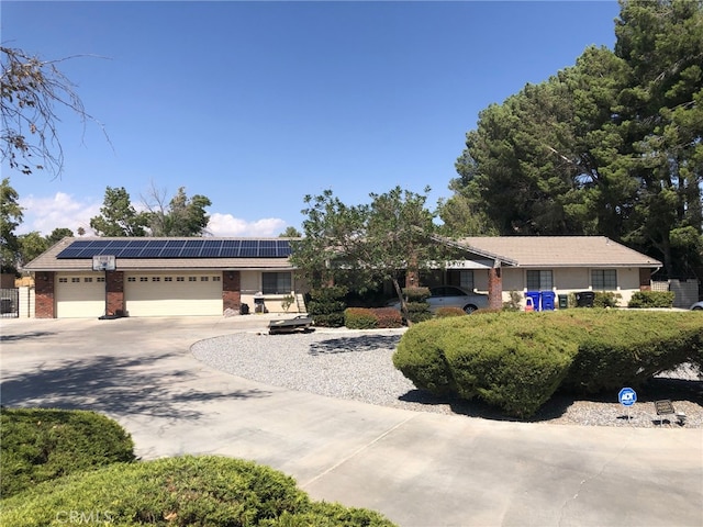 single story home with a garage and solar panels