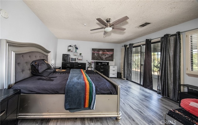 bedroom with a textured ceiling, hardwood / wood-style floors, and ceiling fan