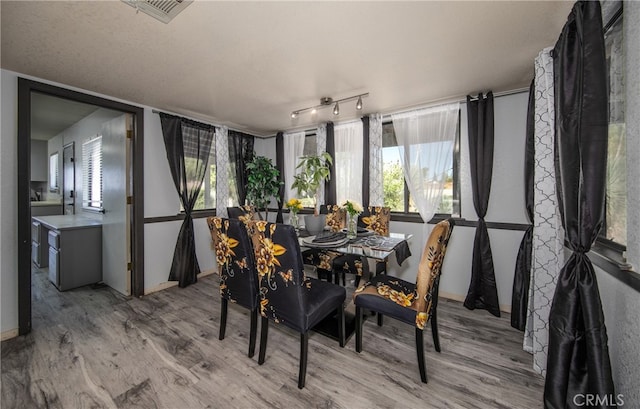 dining space featuring light hardwood / wood-style flooring and a textured ceiling