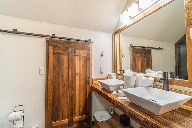 bathroom with wood-type flooring, vanity, and vaulted ceiling