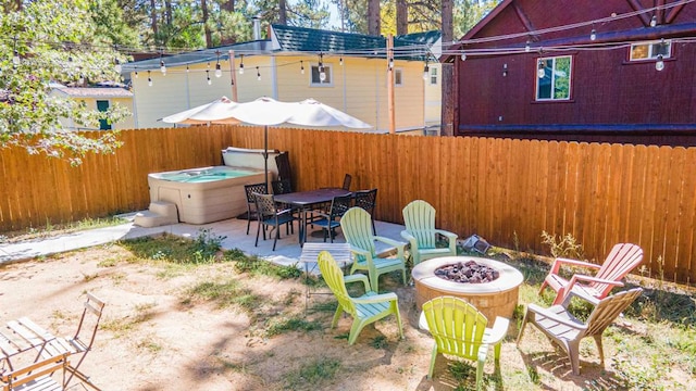 view of patio featuring a hot tub and an outdoor fire pit