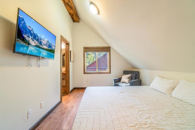 bedroom featuring lofted ceiling with beams and hardwood / wood-style flooring