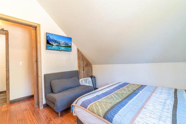 bedroom featuring lofted ceiling and hardwood / wood-style floors