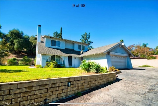 view of front of property featuring a front yard and a garage