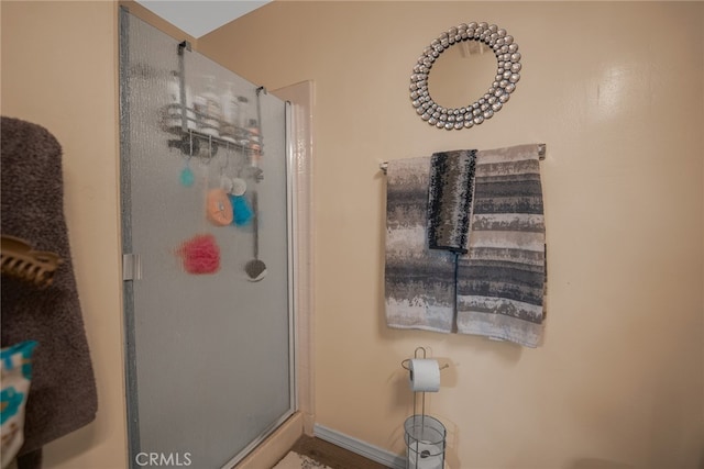 bathroom featuring a shower with shower door