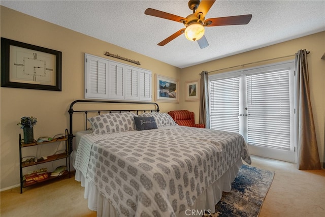 bedroom featuring ceiling fan, light colored carpet, and a textured ceiling