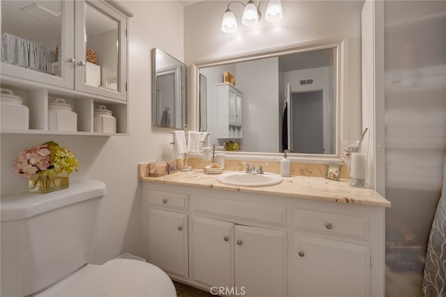 bathroom featuring vanity and toilet