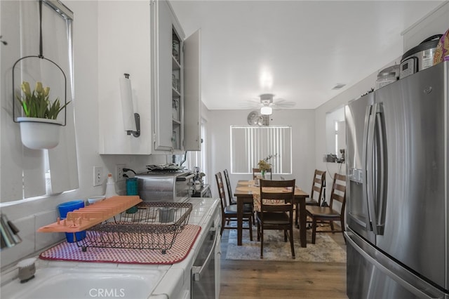 kitchen with stainless steel refrigerator with ice dispenser, ceiling fan, dark wood-type flooring, and sink