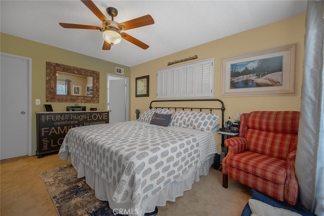 bedroom featuring light carpet, ceiling fan, and a textured ceiling