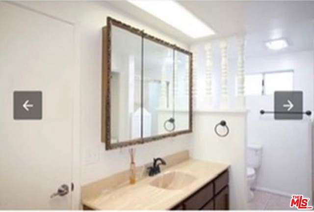 bathroom featuring plenty of natural light, vanity, and toilet