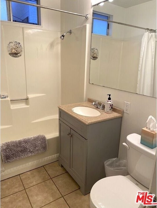 full bathroom featuring vanity, shower / tub combo, toilet, and tile patterned floors