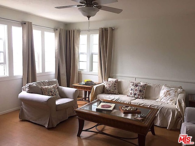 living area featuring a healthy amount of sunlight, hardwood / wood-style floors, and ceiling fan