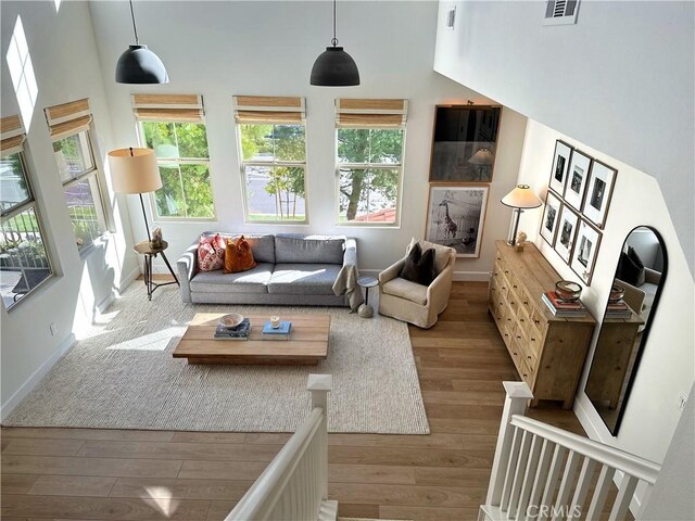 living room with hardwood / wood-style floors and a towering ceiling