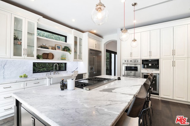 kitchen featuring pendant lighting, stainless steel appliances, and white cabinetry