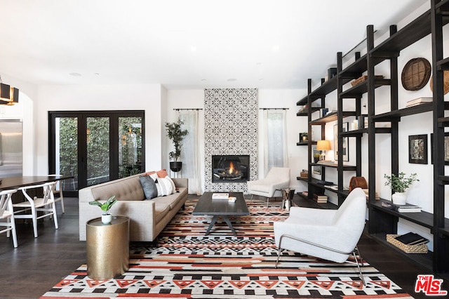 living room featuring dark hardwood / wood-style flooring and a tiled fireplace