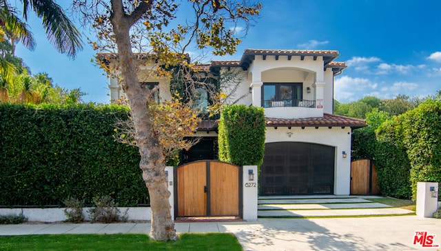 mediterranean / spanish-style house featuring a garage and a balcony