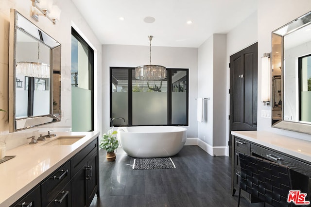 bathroom featuring a washtub, vanity, and a chandelier